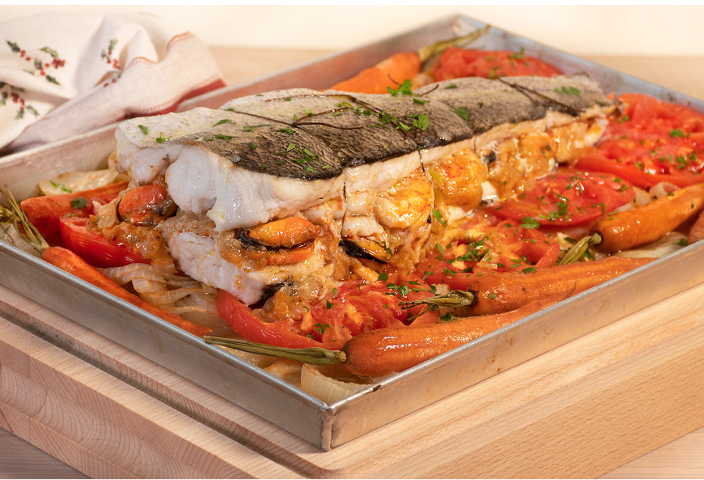 Merluza rellena de marisco con zanahorias y patatas.