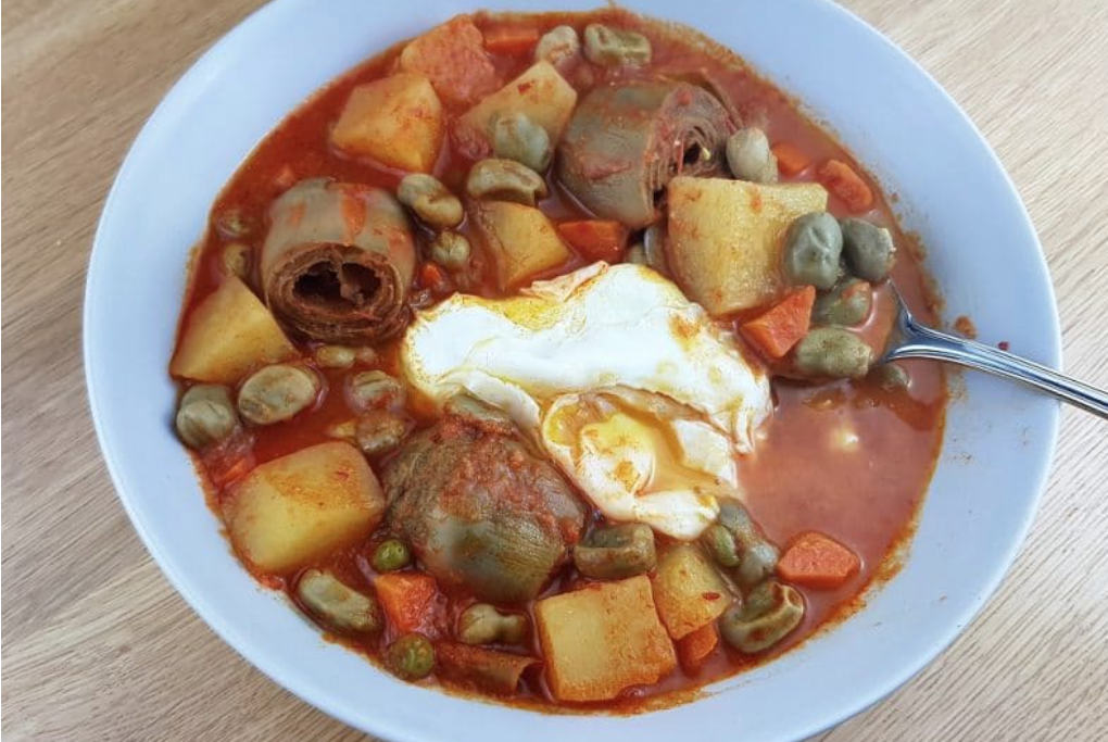 Guiso de habas y alcachofas con huevo escalfado.