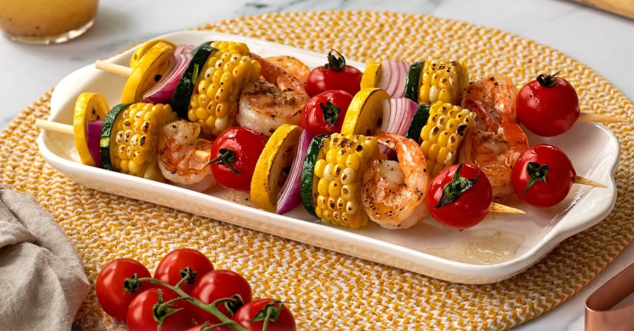 Brochetas de gambas con maíz y verduras
